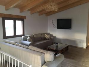 sala de estar con sofá y TV de pantalla plana en Casa Mestres, en Pujalt