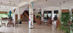 a restaurant with wooden chairs and tables and tables and chairs at Blue Turtle Hotel in Tissamaharama
