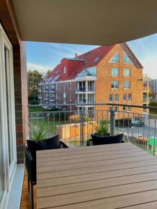 un balcón con mesa y sillas y un edificio en Ferienwohnung Hohe Lith en Cuxhaven