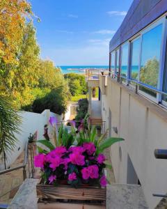 a balcony with flowers and a view of the ocean at Casa Serra in Porto Palo