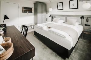 a bedroom with a large bed and a table at Villa Breeksee in Norderney