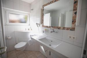 a white bathroom with a sink and a toilet at Hotel Christine in Radolfzell am Bodensee