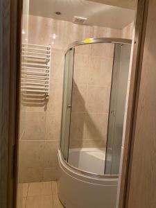 y baño con ducha y puerta de cristal. en Відпочинковий комплекс,міні готель Старий дворик, en Leópolis