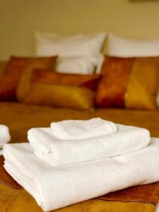 a pile of white towels sitting on top of a table at La Maison, 4 appartements 3 étoiles climatisés au centre ville avec jardin proche du Parc et des Thermes in Lons-le-Saunier