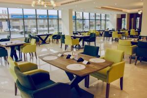 - une salle à manger avec des tables, des chaises et des fenêtres dans l'établissement Hayat Al Riyadh Washam Hotel, à Riyad