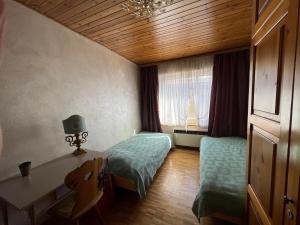 Habitación con 2 camas, escritorio y ventana. en Chesa Sonnalpine B 33 en St. Moritz