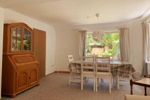 a dining room with a table and chairs and a window at Nordseehaus Muschel in Dornum