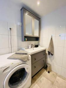 a washing machine in a bathroom with a sink at Nordseehaus Muschel in Dornum +21 photos