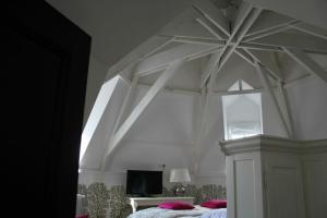 a bedroom with a white canopy bed with pink pillows at Villa Adélaïde in Chimay
