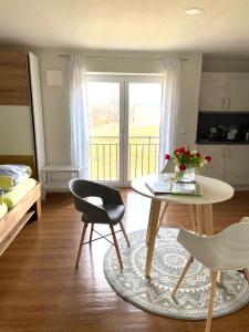 a living room with a table and chairs and a bed at Ferienwohnung Mohr in Kißlegg