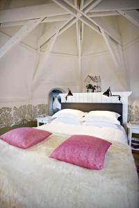 a bedroom with a large bed with two pink pillows at Villa Adélaïde in Chimay