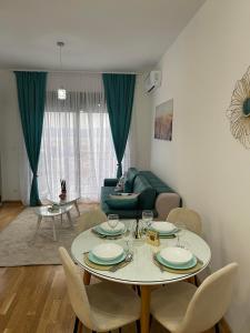 a living room with a table and chairs and a couch at Apartman Iva in Tivat