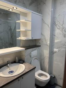 a white bathroom with a sink and a toilet at Apartman Iva in Tivat
