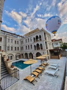 a large building with a pool and a hot air balloon at Grand Cappadocia Hotel in Göreme