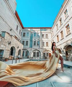 a woman in a gold dress posing in front of a building at Grand Cappadocia Hotel in Goreme