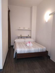 una camera da letto con un letto, pareti bianche e pavimenti in legno di Cinque Terre Step a La Spezia