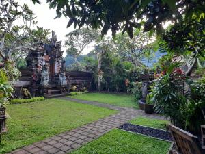un jardin avec un chemin au milieu dans l'établissement Sahadewa House, à Ubud