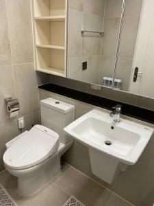 Un baño con un inodoro blanco y un lavabo. en ЖК Highvill Ishim D1, en Astana 8 fotos más