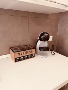 a tea and coffee machine next to a box on a counter at Appartamento cittadella in Verona