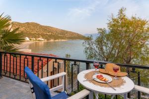 a table with a glass of wine on a balcony at SeaView Apartment & Studios in Psili Ammos