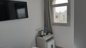 a room with a window and a toilet and a tv at La Veranda Hotel in Larnaca