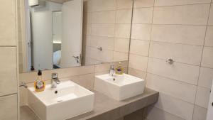 a bathroom with two white sinks and a mirror at La Veranda Hotel in Larnaca