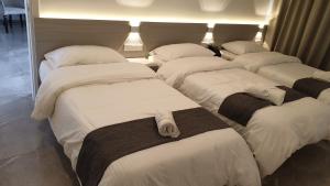 a group of four beds in a room at La Veranda Hotel in Larnaca