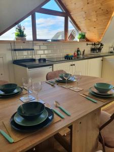 a wooden table with plates and wine glasses on it at Mount Bolton Apartment in Portlaw