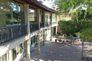 un edificio con balcones y un patio con bancos en Lo Schiaccianoci Bed&Breakfast de Charme, en Scanzorosciate