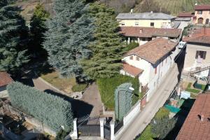 - une vue sur une maison avec des arbres dans la cour dans l'établissement Lo Schiaccianoci Bed&Breakfast de Charme, à Scanzorosciate