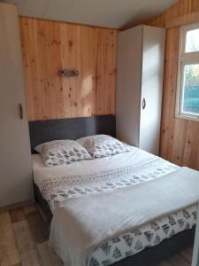 - une chambre avec un lit et un mur en bois dans l'établissement Gîtes du Bois de Bontemps, à Sarlat-la-Canéda