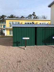 a street sign in front of a green building at FEWO Meerhund in Graal-Müritz in Gelbensande