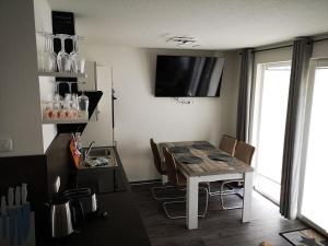 a kitchen with a table with chairs and a television at FEWO Meerhund in Graal-Müritz in Gelbensande