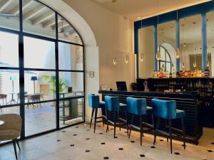 a restaurant with a bar with blue chairs at Hotel Basilica in Palma de Mallorca