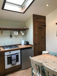 a kitchen with a stove and a wooden table at sika lodge in Wareham