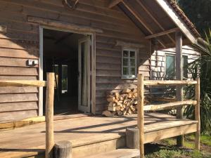 una puerta abierta de una cabaña de madera con porche en sika lodge, en Wareham