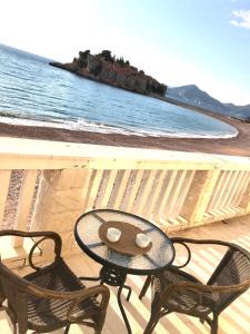 a table and two chairs on a balcony overlooking the ocean at Lovely Apartment Sveti Stefan in Sveti Stefan