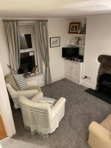 a living room with two chairs and a couch at 7 Mersey Street, Borth-y-Gest in Porthmadog