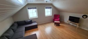 a living room with a couch and a red chair at Cheerful 4-bedroom home with fireplace, 1,5km from Flåm center in Aurland