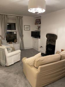 a living room with two couches and a fireplace at 7 Mersey Street, Borth-y-Gest in Porthmadog