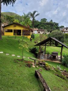 a yellow house with a picnic table in a yard at Espaço inteiro: Casa de campo nas montanhas in Domingos Martins