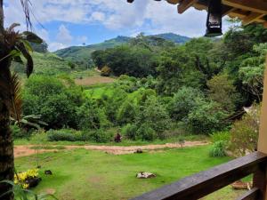 - une vue depuis la terrasse couverte d'une maison avec un champ verdoyant dans l'établissement Espaço inteiro: Casa de campo nas montanhas, à Domingos Martins
