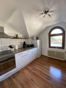 a kitchen with white cabinets and a ceiling fan at Haus am Hang in Bernkastel-Kues
