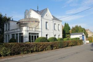 a large white house with a large window at Villa Adélaïde in Chimay