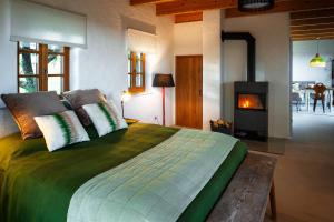 ein Schlafzimmer mit einem großen Bett und einem Kamin in der Unterkunft Ferienhaus mit privaten Schwimmteich und Sauna in Oed bei Gleisdorf