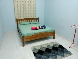 a bed with two pillows on it in a room at Ummi's Homestay Kuala Besut in Kampong Baru