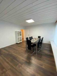 una sala de reuniones con mesa y sillas en una oficina en Geräumige Wohnung im Schweizer Vekehrspunkt, en Hunzenschwil