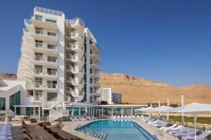エイン・ボケックにあるHerbert Samuel Hod Dead Sea Hotelの建物の隣にスイミングプールがあるホテル