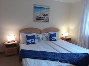 a bedroom with a bed with blue and white pillows at Lilia Sun Apartment in Sozopol