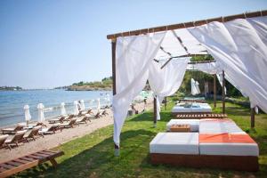 a group of beds on the beach with chairs at Lilia Sun Apartment in Sozopol